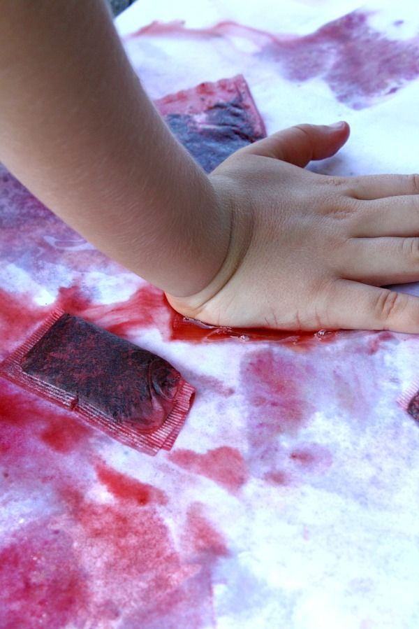 This may contain: a child's hand on wax paper with red dye