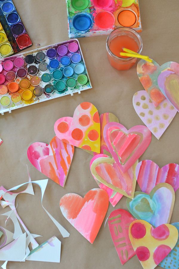 This may contain: some paper hearts are sitting on a table with paint and watercolors in the background