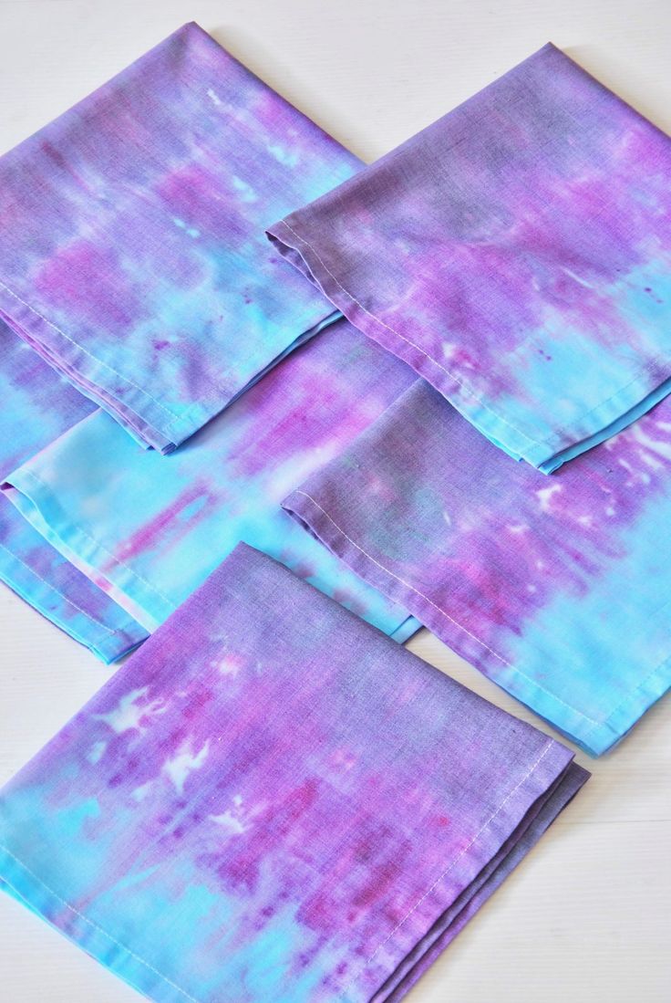 This may contain: four purple and blue tie dye napkins on a white surface