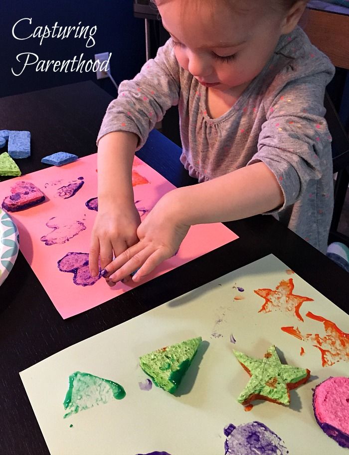 This may contain: a young child is making crafts with colored paper