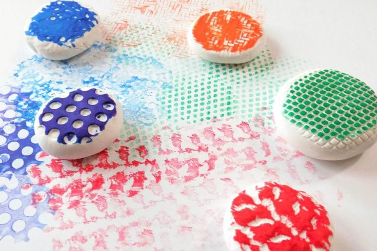 This may contain: four different colored buttons sitting on top of a white paper covered table with polka dot designs
