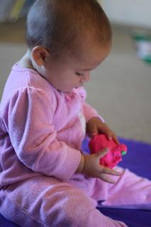 A baby playing with a toy

Description automatically generated