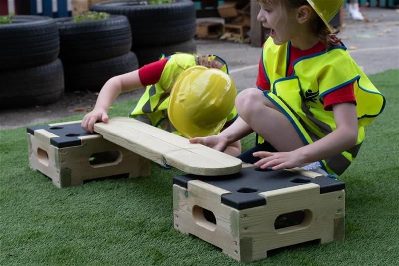 A young boy placing the plank onto the plank