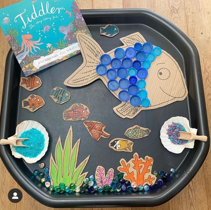 This may contain: an ocean themed tray with paper plates and magnets