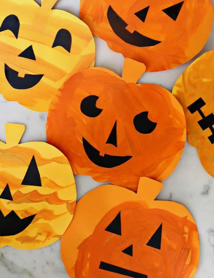 Jack-o-lantern craft for kids with cut out pumpkins and faces glued on.