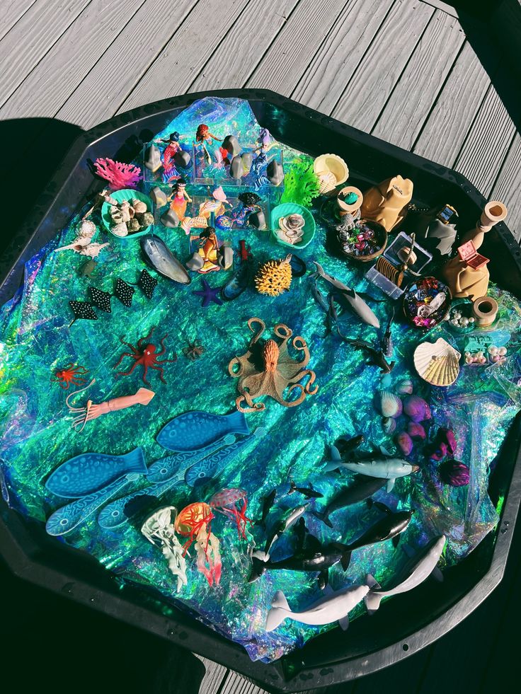 This may contain: there is a tray that has many different things on top of it, including sea animals and mermaids