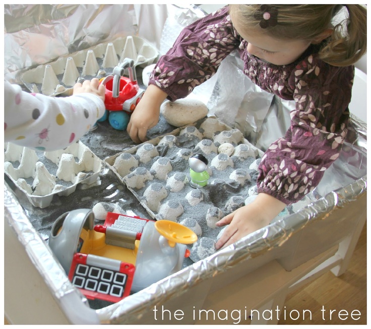 This may contain: two children playing with toys in an ice tray
