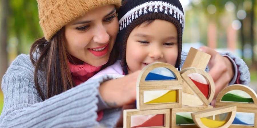 constructive play-mother and son playing with wooden stacking blocks