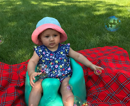 Wike Baby in Bumbo seat reaching for bubbles